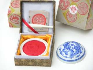 The red seal ink is held in a traditional style blue and white 